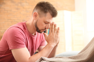 Religious man praying at home