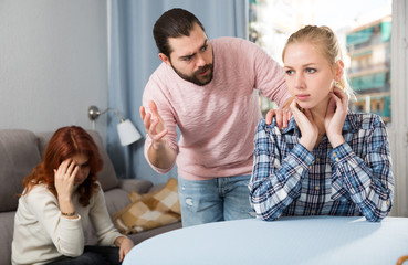 Young spouses and mother-in-low arguing indoors