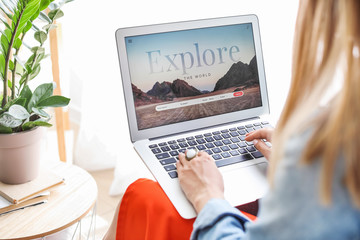 Woman with laptop visiting travel agency website at home