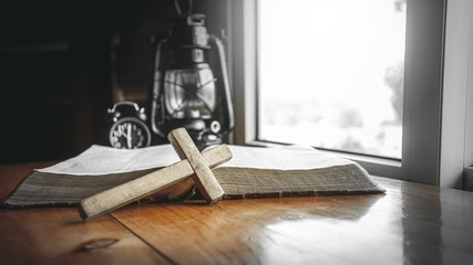 Close up of cross with old bible. christian concept.