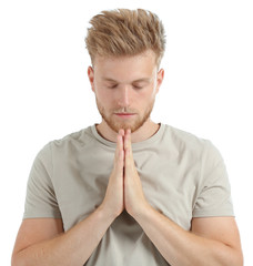 Fototapeta na wymiar Religious young man praying to God on white background