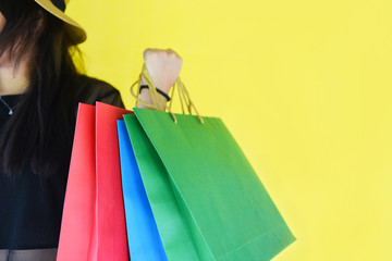Woman holding shopping bags for girl fashion shopping in the summer colorful yellow