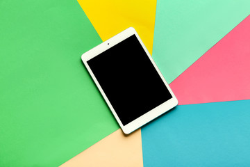 Modern tablet computer on color background