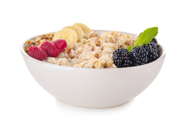 Bowl with tasty sweet oatmeal on white background