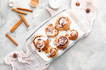 Baking tray with tasty cinnamon buns on grunge background