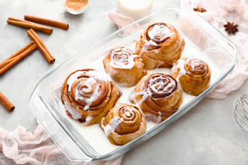 Baking tray with tasty cinnamon buns on table