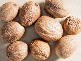 Nutmegs (Myristica fragrans) on a beige background