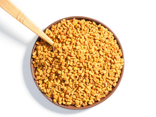 Spice Fenugreek (Trigonetla) spice on a white background with spoon