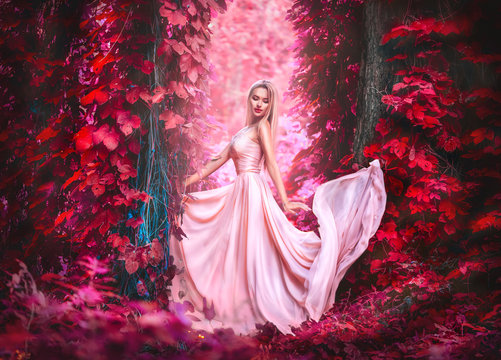 Beauty romantic young woman in long chiffon dress with gown posing in fantasy misty forest. Beautiful happy bride model girl enjoying nature outdoors
