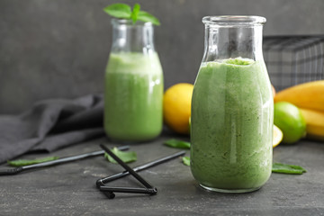 Bottle of healthy smoothie on grey table