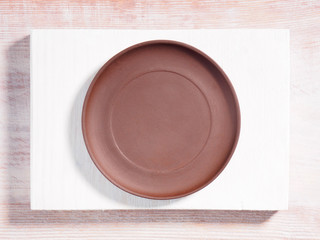 Brown clay plates on a wooden background