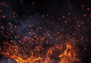 Fototapeta na wymiar Burning sparks flying. Beautiful flames. Fiery orange glowing flying away particles on black background.