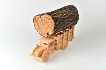Wooden toy truck with a load of logs. Lumber delivery concept.