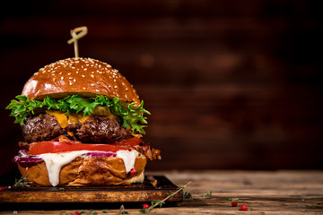 Close-up of home made tasty burger on wooden table. - obrazy, fototapety, plakaty
