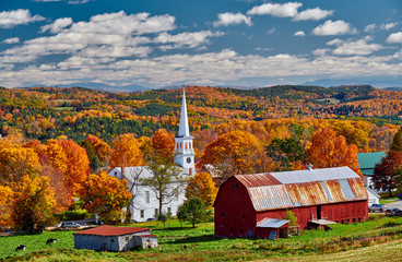 Congregational Church and farm with red barn at sunny autumn day in Peacham, Vermont, USA
