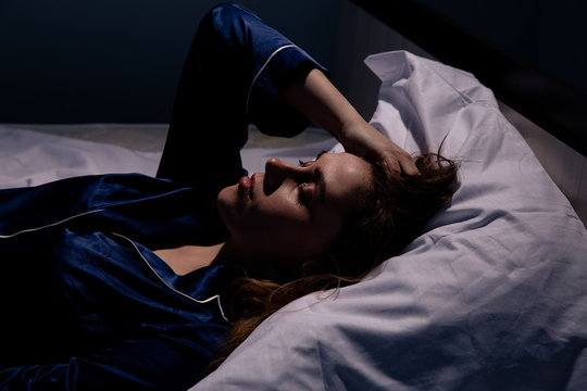 Upset woman lying in bed in sleepless