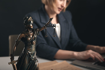 Woman lawyer working on a computer sitting at the table in office isolated