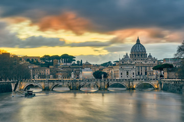Fototapeta premium St. Peter's cathedral and Tiber river with high water at evening with dramatic sunset sky. Saint Peter Basilica in Vatican city with Saint Angelo Bridge in Rome, Italy