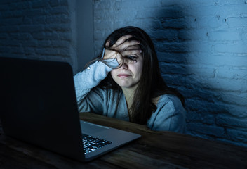 Scared woman on laptop in the dark feeling fear suffering online harassment and cyberbullying © SB Arts Media
