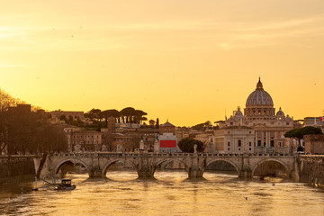 Fototapeta premium St. Peter's cathedral and Tiber river with high water at sunset. Saint Peter Basilica in Vatican city with Saint Angelo Bridge in Rome, Italy