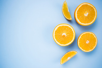 Oranges pieces of citrus on a blue background. Flat lay. Place for text.