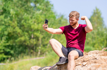 Fit man using smartphone to take a selfie photo during training outdoor