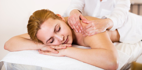 Obraz na płótnie Canvas Woman taking massage in salon