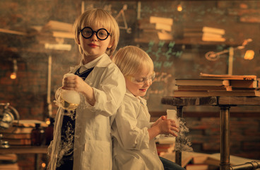 small researchers standing back to back holding test tubes