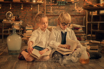 Fototapeta na wymiar preschooler researchers reading books of chemistry in the lab