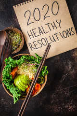 2020 new year, healthy resolutions. Buddha bowl on a dark background.
