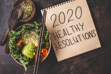 2020 new year, healthy resolutions. Buddha bowl on a dark background.