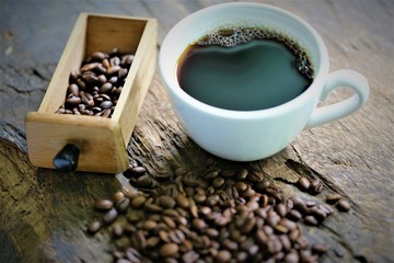 cup of coffee and beans on wooden table