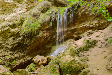 Small waterfall in the summer rocky slope