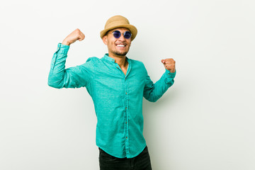 Young hispanic man wearing a summer clothes raising fist after a victory, winner concept.