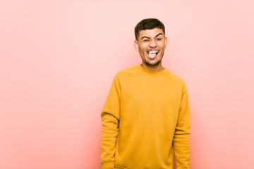 Young hispanic man funny and friendly sticking out tongue.