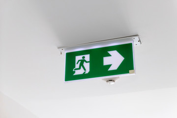 Fire exit sign. Emergency fire exit door exit door on ceiling. Green emergency exit sign showing...