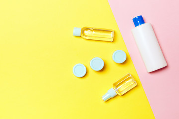 Group of plastic bodycare bottle Flat lay composition with cosmetic products on yellow and pink background empty space for you design. Set of White Cosmetic containers, top view with copy space