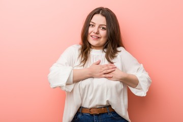 Fototapeta premium Young caucasian curvy woman standing against pink background