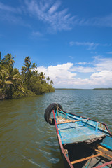 Canoeing on backwaters of Munroe islands, Kerala, India. Serenely tropical island with coconut trees and rivers. Clear reflections on Ashtamudi lake. Peaceful boating at sun rise. Kollam district