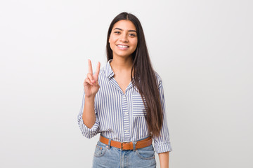 Young pretty arab woman showing victory sign and smiling broadly.