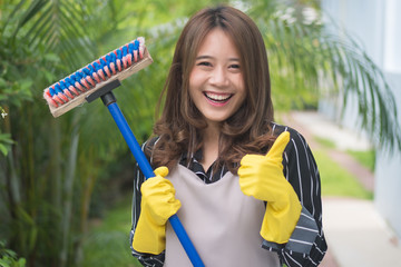 happy woman mopping the floor, doing housework, giving thumb up
