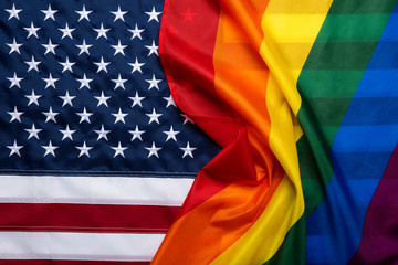 Pride rainbow lgbt gay flag over American US flag . Equality diversity freedom in USA concept.