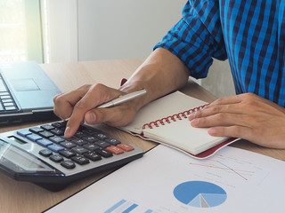 Accounting concept Men's hand uses a calculator to calculate statistics. About his work Calculate...