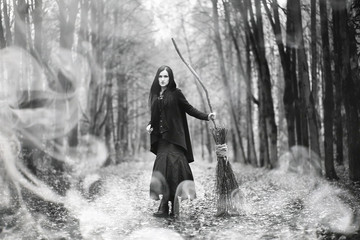Woman in a witch suit in a dense forest
