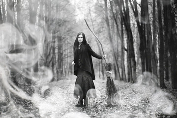 Fototapeta premium Woman in a witch suit in a dense forest