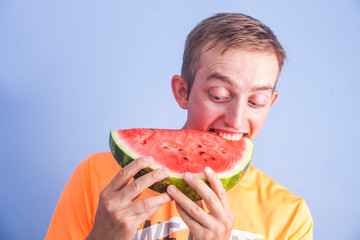 Young handsome man eats watermelon