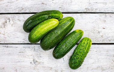 Cucumbers on a white wooden board