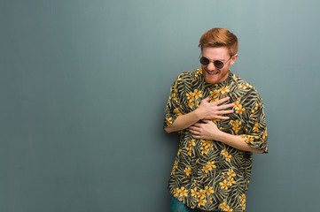 Young redhead man wearing exotic summer clothes laughing and having fun