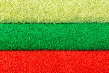 Background from terry towels of three colors. Light green dark green and bright orange texture....