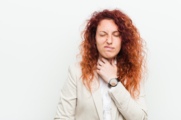 Young natural redhead business woman isolated against white background suffers pain in throat due a virus or infection.